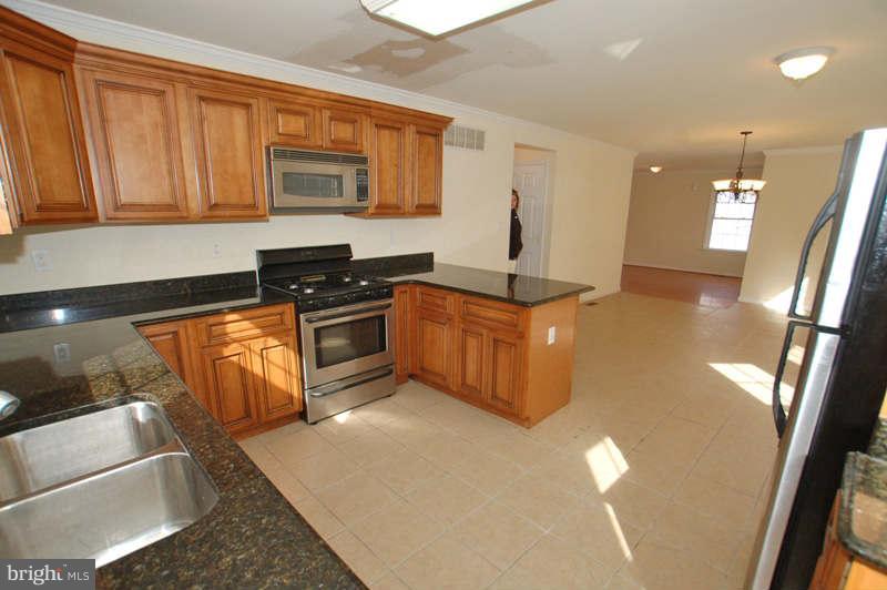 3641 Clifmar Road Baltimore, MD 21244 - Photo 5 of 27 a kitchen with stainless steel appliances granite countertop a stove a sink and a microwave