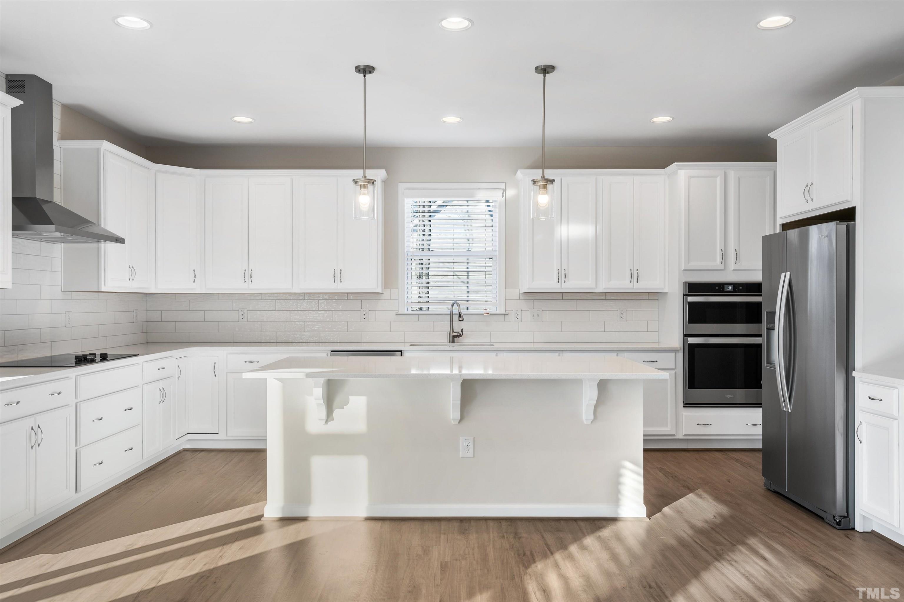 177 Karlov Road Garner, NC 27529 - Photo 11 of 39 a kitchen with stainless steel appliances granite countertop a sink a stove a refrigerator and island with wooden floor