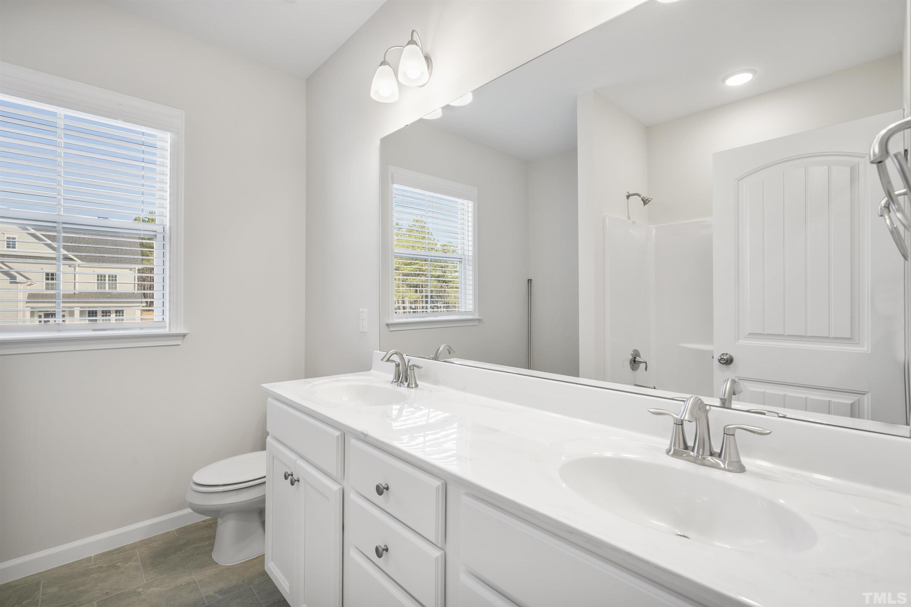 177 Karlov Road Garner, NC 27529 - Photo 28 of 39 a bathroom with a granite countertop toilet a sink and a mirror