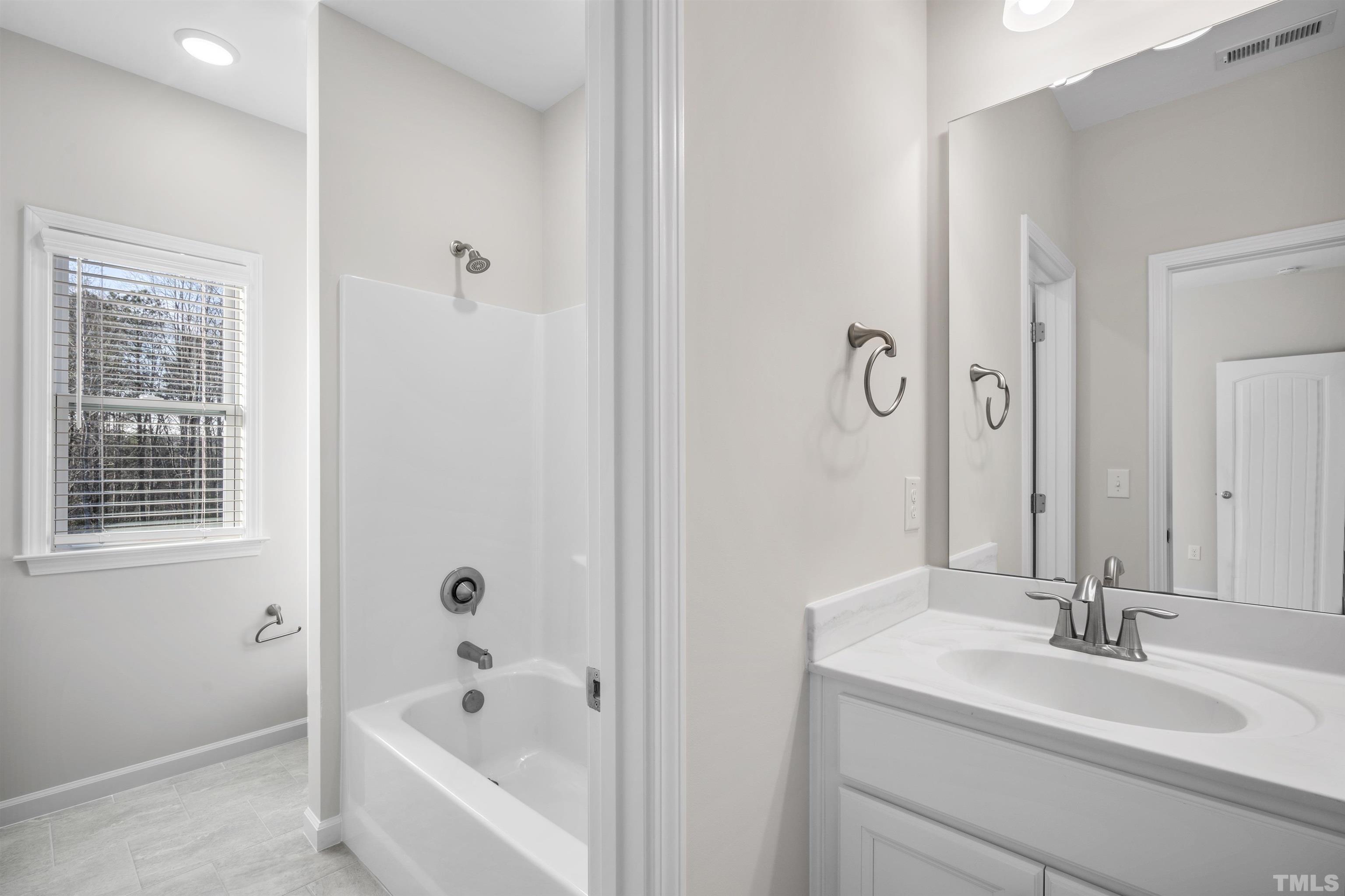 177 Karlov Road Garner, NC 27529 - Photo 32 of 39 a bathroom with a tub sink and mirror