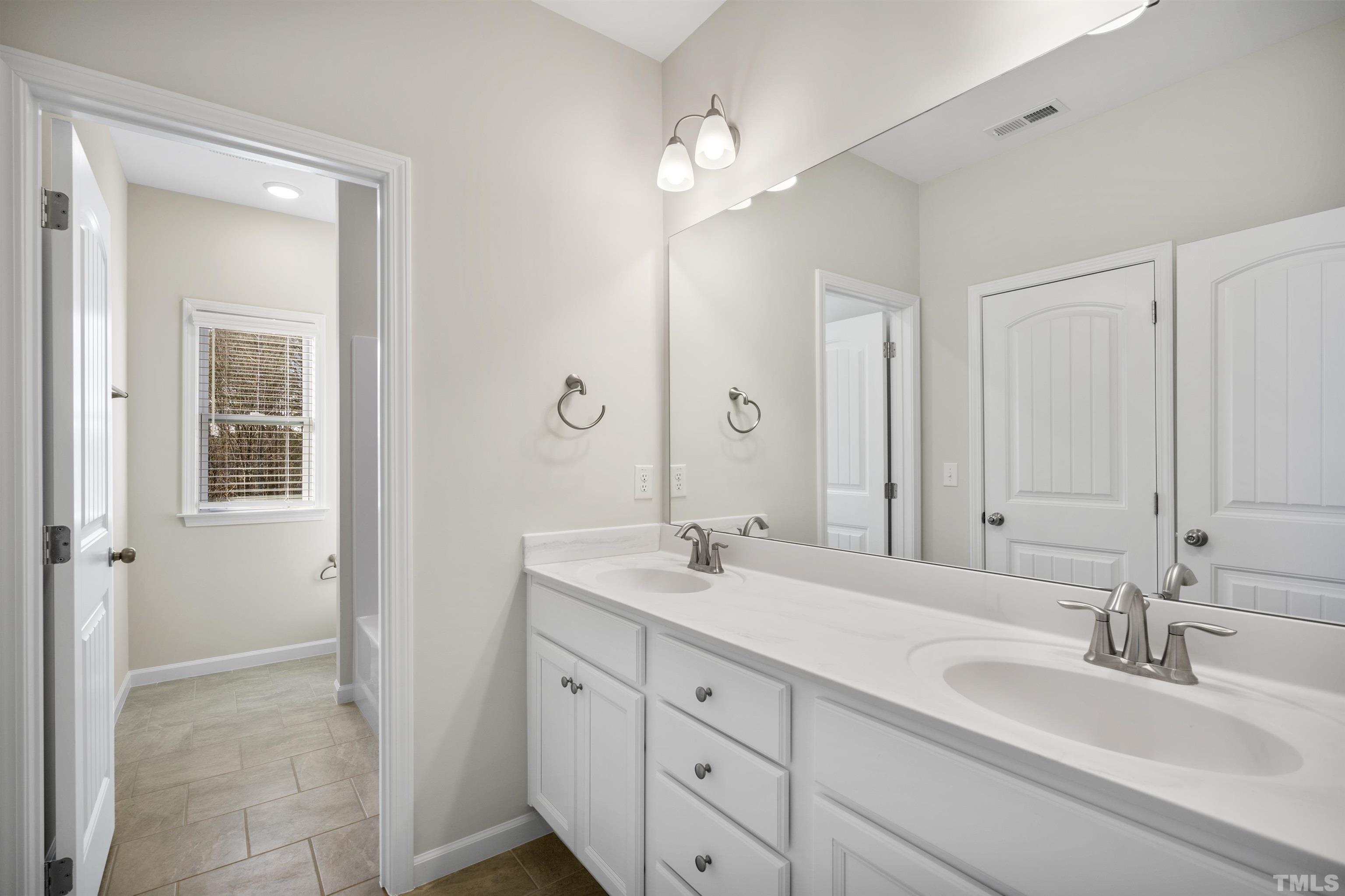 177 Karlov Road Garner, NC 27529 - Photo 33 of 39 a bathroom with double sink and a mirror