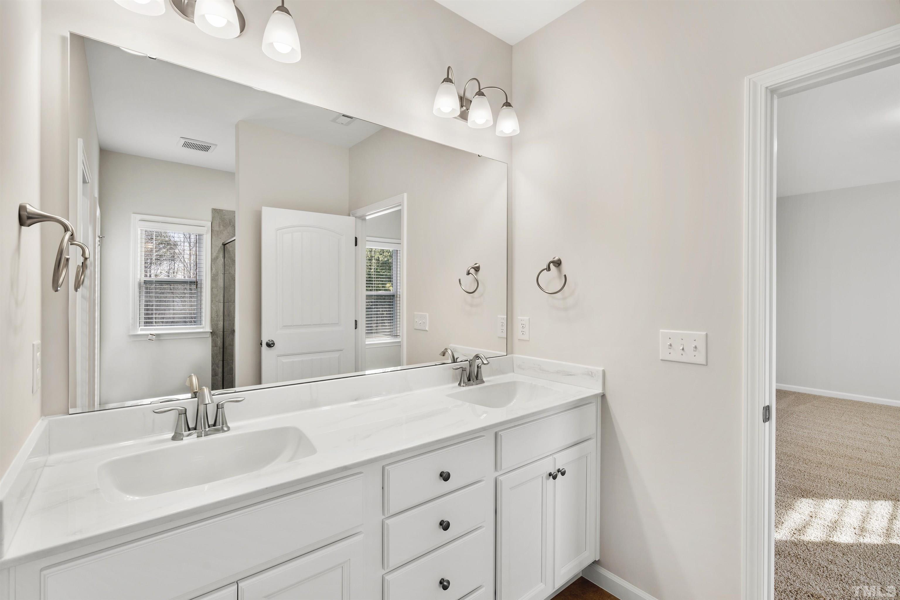 177 Karlov Road Garner, NC 27529 - Photo 35 of 39 a bathroom with double vanity sinks and a mirror