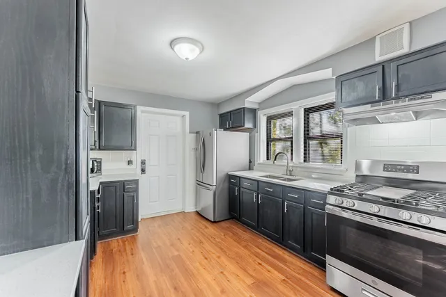 a kitchen with stainless steel appliances granite countertop a stove and a sink