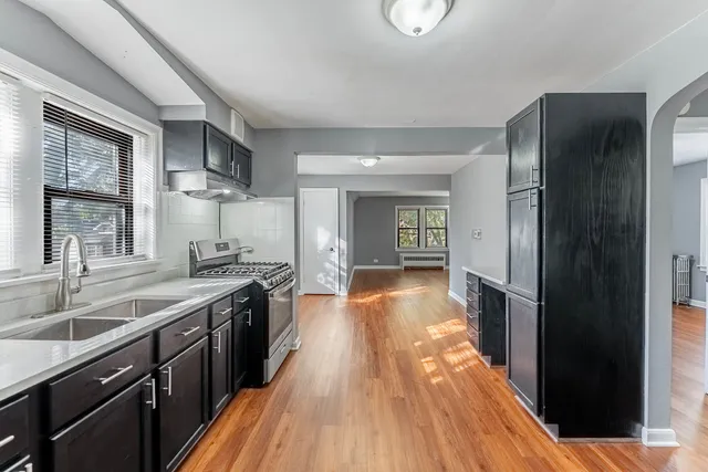 a view of a kitchen with a sink and wooden floor