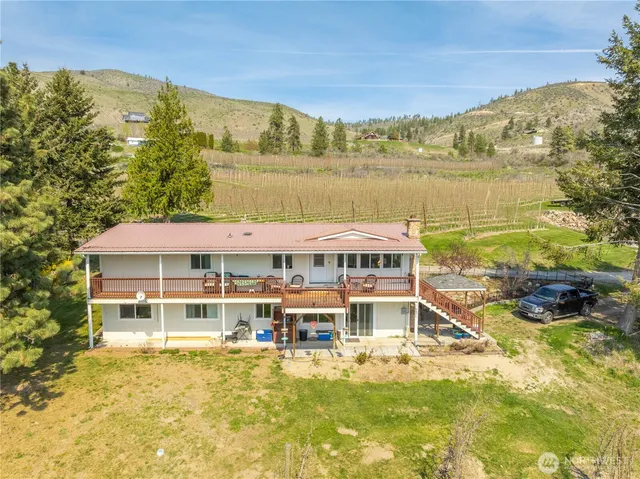 a view of a large pool with lawn chairs and a large tree