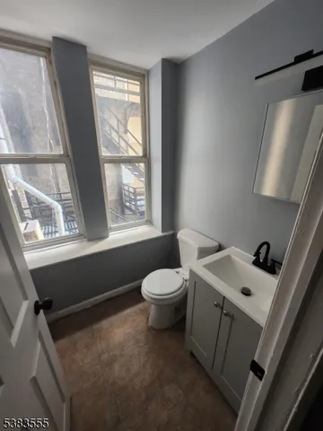 a bathroom with a sink a toilet and a window