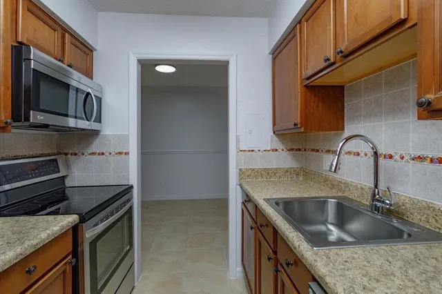 a kitchen with granite countertop a sink and a stove top oven