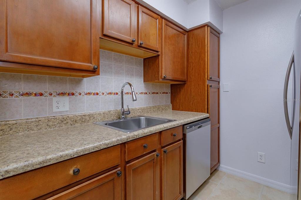 395 Wymore Road, Unit 207 Altamonte Springs, FL 32714 - Photo 5 of 32 a kitchen with stainless steel appliances granite countertop a sink and cabinets