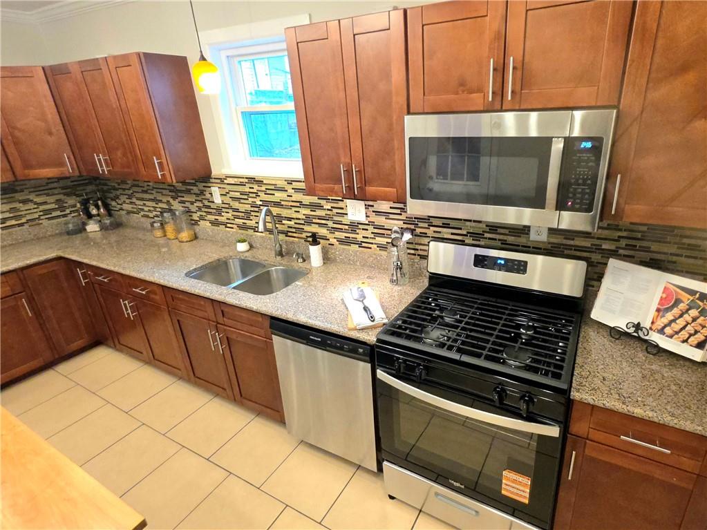 5232 Keystone Street Pittsburgh, PA 15201 - Photo 29 of 48 a kitchen with stainless steel appliances a stove a microwave and sink