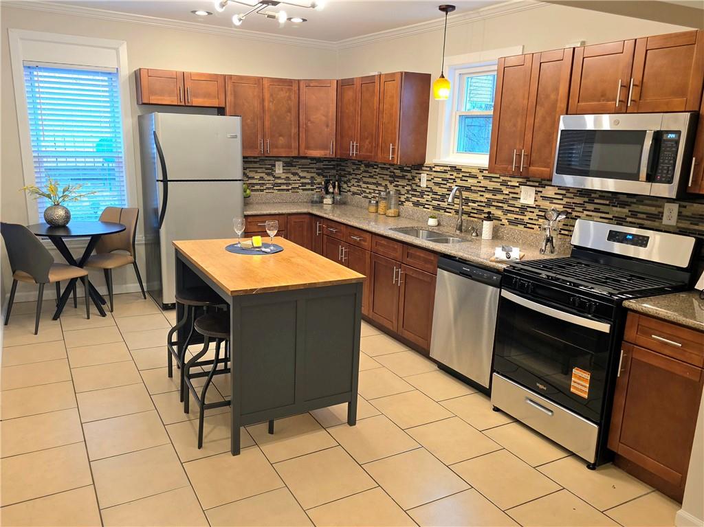 5232 Keystone Street Pittsburgh, PA 15201 - Photo 8 of 48 a kitchen with stainless steel appliances granite countertop a stove a sink a microwave and a refrigerator