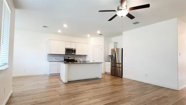 a kitchen with stainless steel appliances a refrigerator and a stove top oven