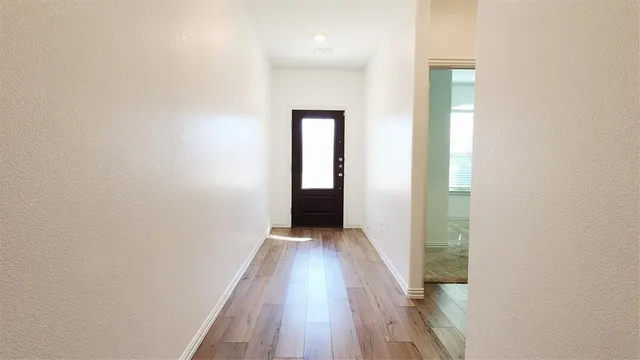 a view of a hallway with wooden floor