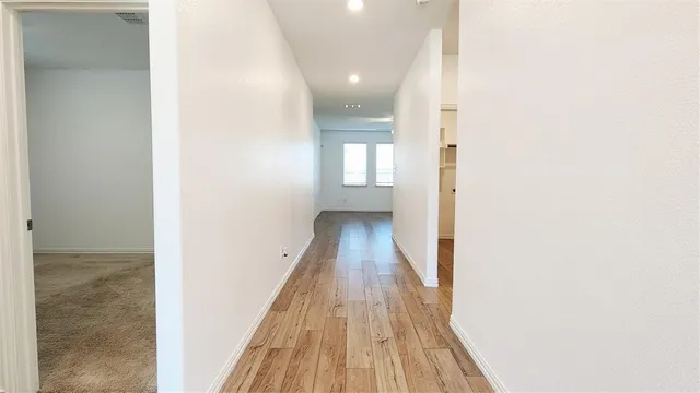 a view of a hallway with wooden floor