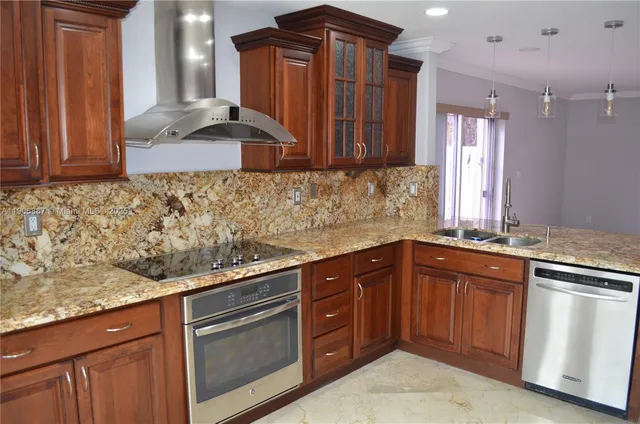 a kitchen with stainless steel appliances granite countertop wooden cabinets a sink and dishwasher