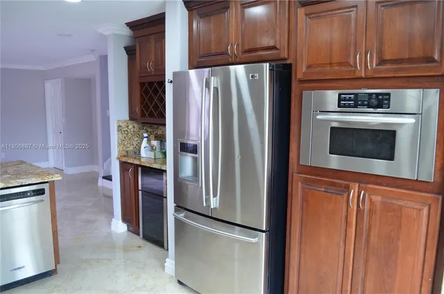 a metallic refrigerator freezer sitting in a kitchen