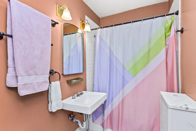 a bathroom with a sink a mirror and a shower curtain