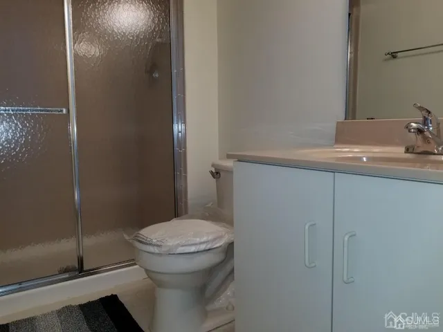 a bathroom with a granite countertop toilet and a sink