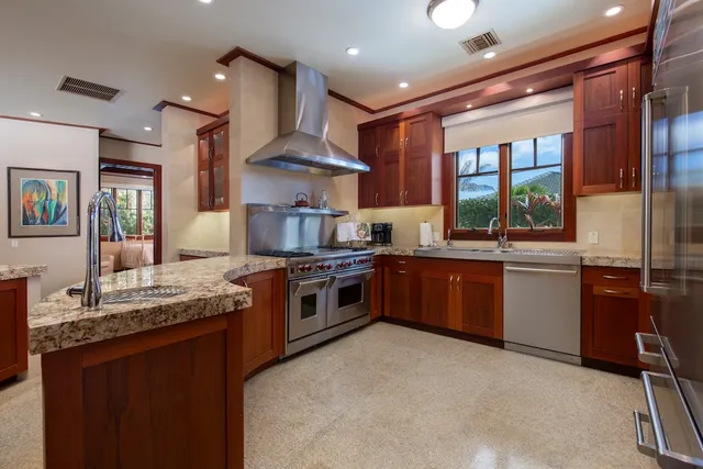 a large kitchen with stainless steel appliances granite countertop a stove and a sink