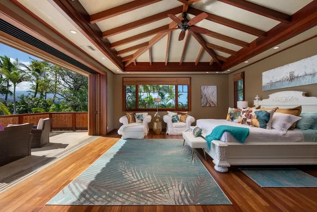 a bedroom with furniture and a large window