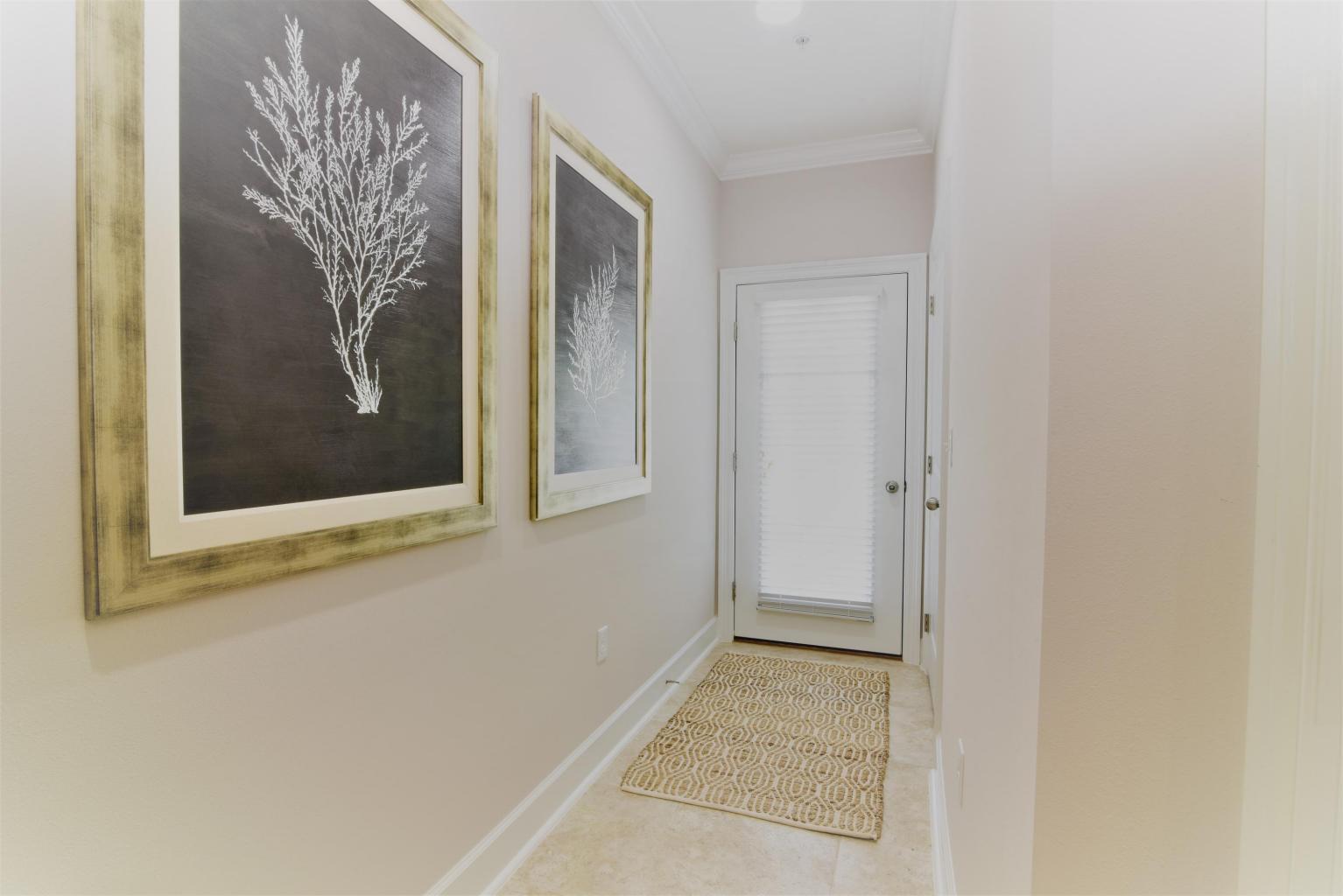 257 Driftwood Road, Unit 2 Miramar Beach, FL 32550 - Photo 7 of 41 a view of a hallway with paintings on the wall