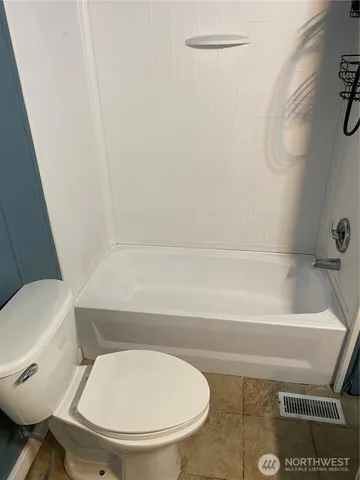 a bathroom with a toilet and a bathtub