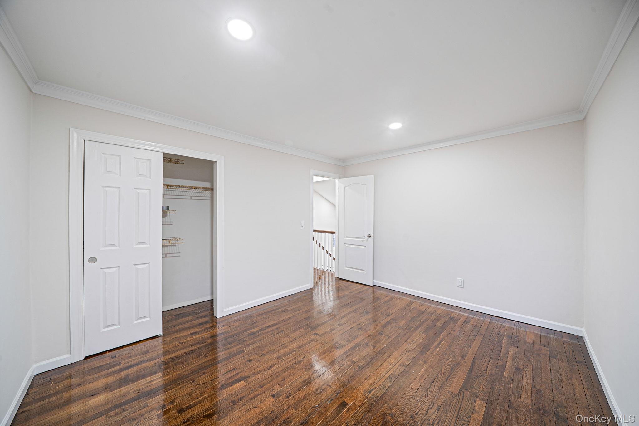 119 Foster Road Ronkonkoma, NY 11779 - Photo 18 of 26 Unfurnished bedroom with ornamental molding, dark wood-style flooring, recessed lighting, and a closet