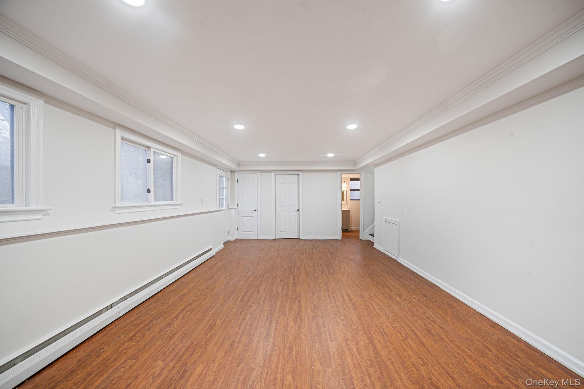 119 Foster Road Ronkonkoma, NY 11779 - Photo 26 of 26 Unfurnished room featuring a baseboard radiator, crown molding, recessed lighting, and wood finished floors