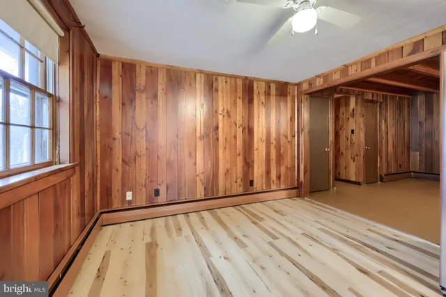 a view of an empty room with window wooden floor and a kitchen