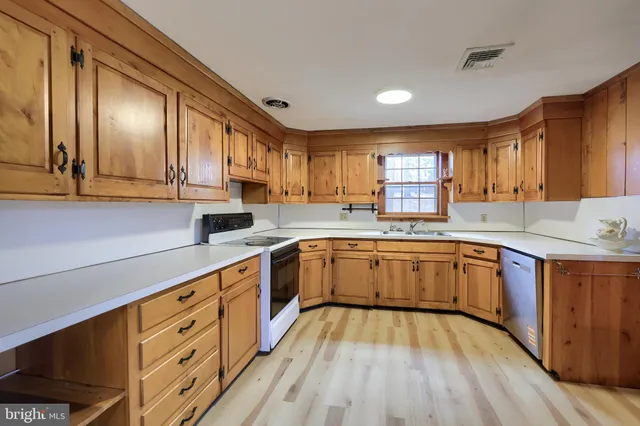 a large kitchen with stainless steel appliances sink a microwave and cabinets