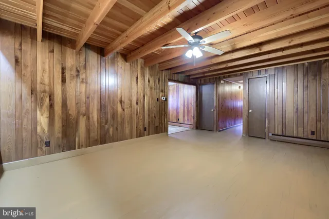 a view of an empty room with a fireplace and window
