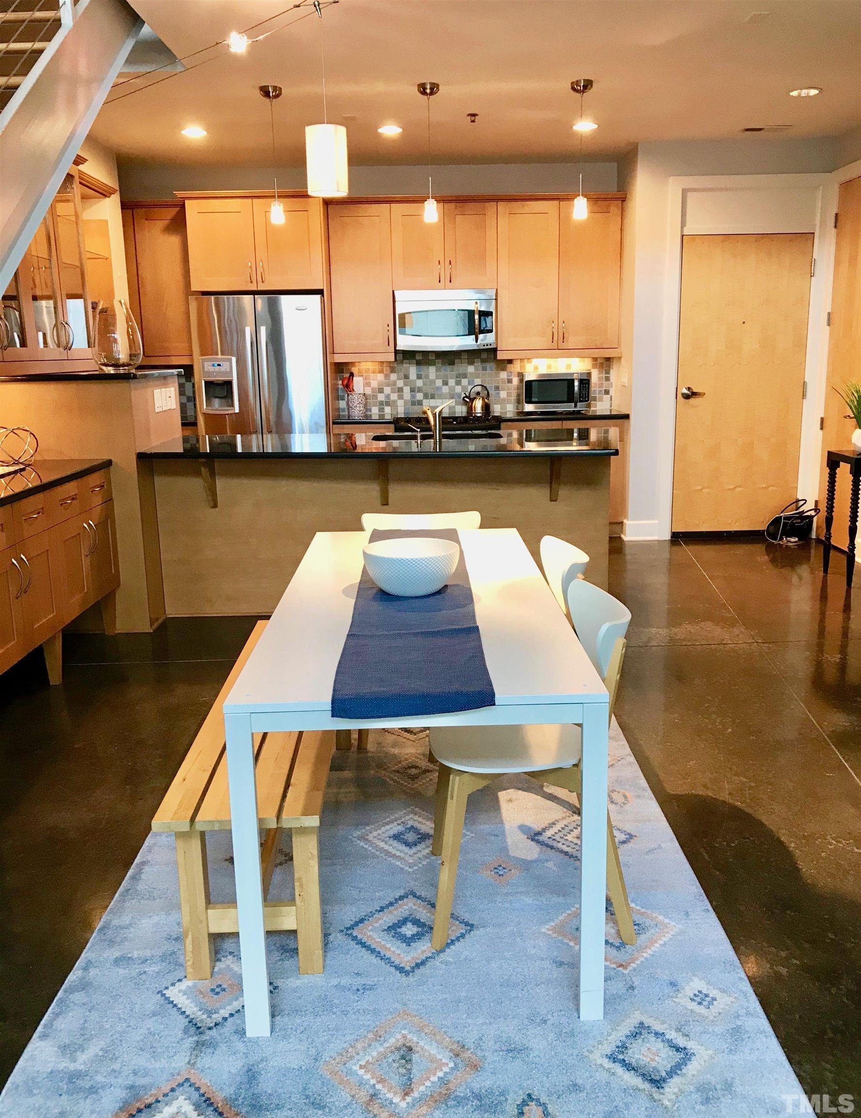 2608 Erwin Road, Unit 417 Durham, NC 27705 - Photo 10 of 39 a kitchen with a table chairs refrigerator and microwave