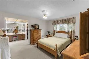 a bedroom with a bed and dresser with mirror