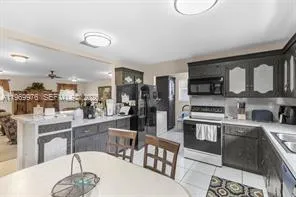 a kitchen with stainless steel appliances granite countertop a stove a sink dishwasher a dining table and chairs with wooden floor