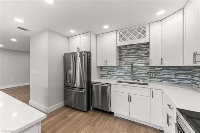 a large kitchen with kitchen island a white counter space a sink appliances and cabinets