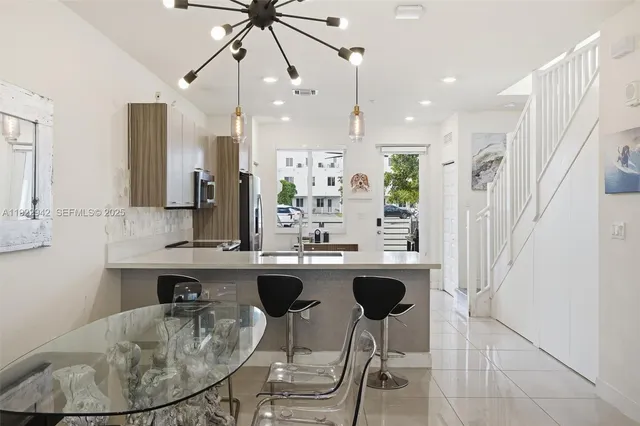 a kitchen with kitchen island granite countertop a sink a center island stainless steel appliances and cabinets