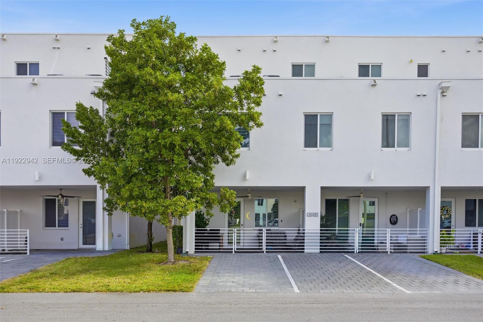 6420 Northwest 102nd Path, Unit 110 Doral, FL 33178 - Photo 13 of 47 a view of a white house with large windows and a small yard