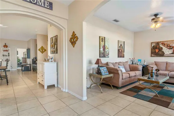 a living room with stainless steel appliances furniture and a kitchen view