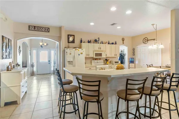 a kitchen with a dining table chairs cabinets and stainless steel appliances