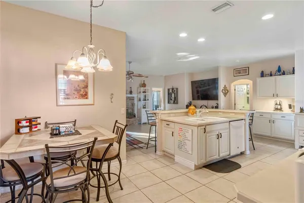 a living room with furniture a flat screen tv and kitchen view