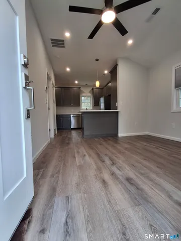 an empty room with wooden floor and windows