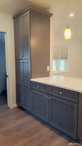 a room with a chandelier fan and a window