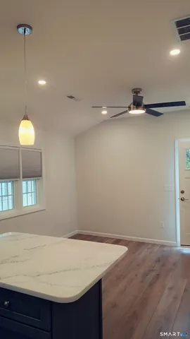a view of an empty room with wooden floor and cabinet