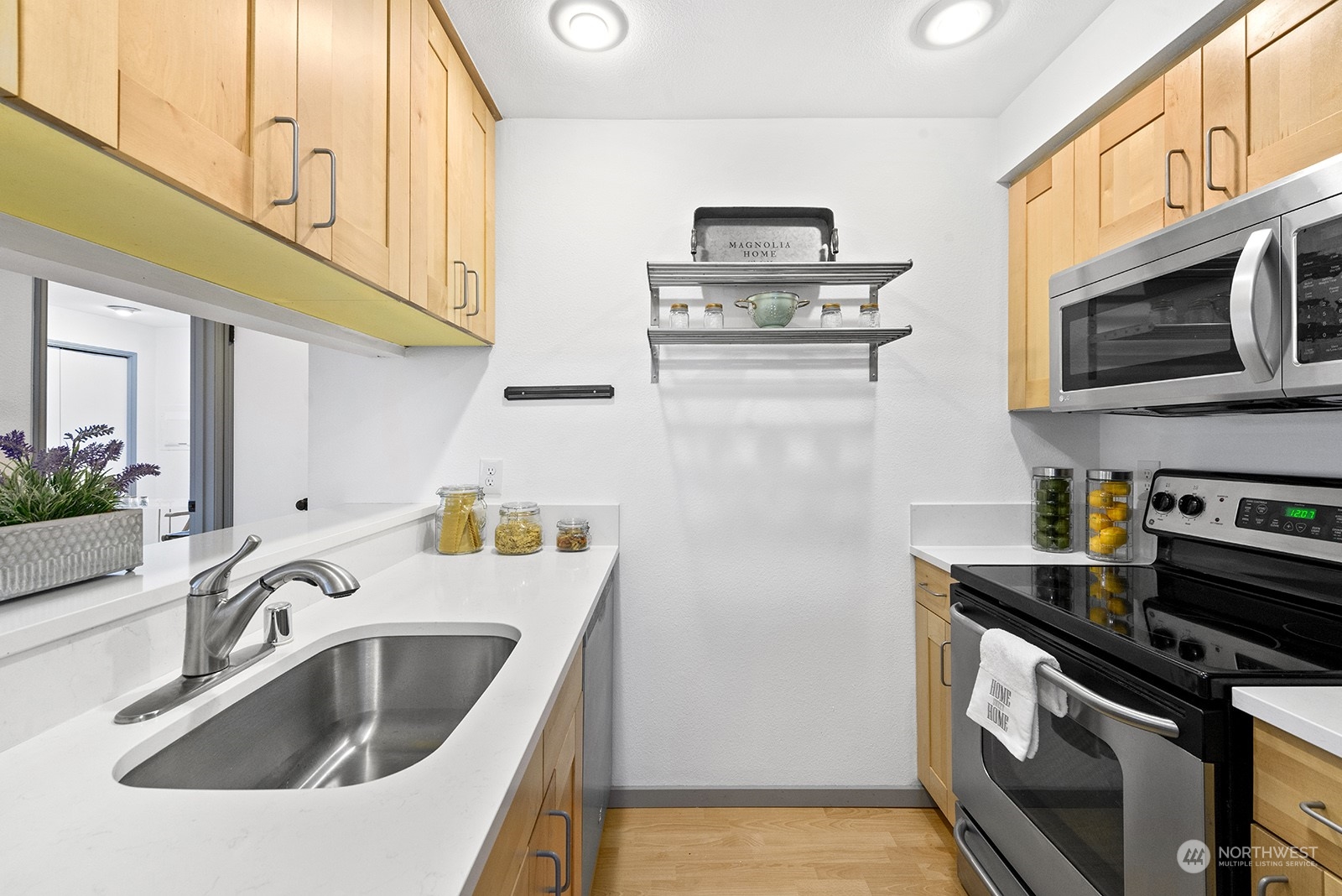 4118 58th Place Southwest, Unit 2 Seattle, WA 98116 - Photo 12 of 23 a kitchen with stainless steel appliances a sink a stove and a microwave