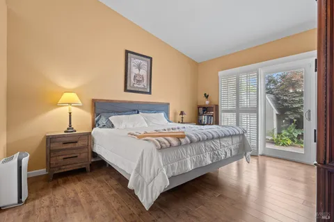a bedroom with a bed painting and wooden floor