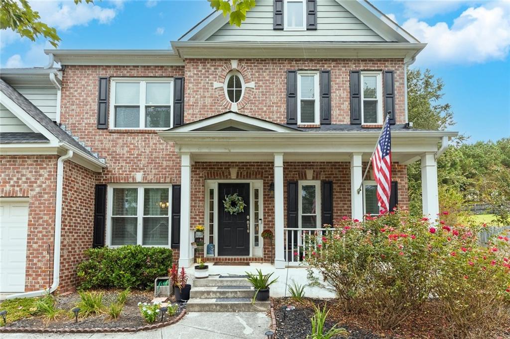 front view of a brick house with a yard