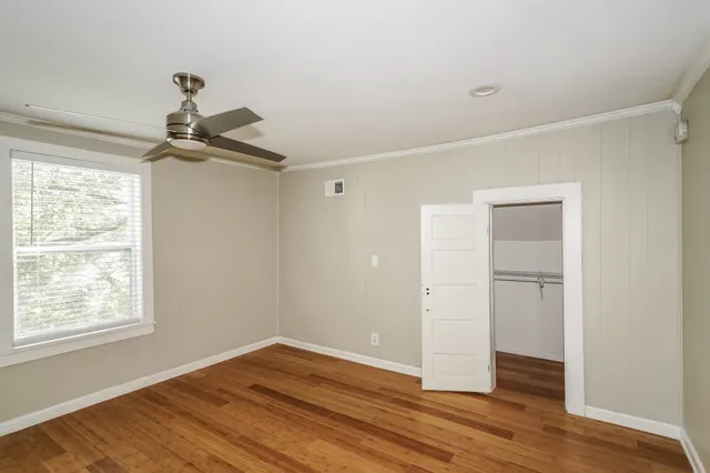a view of a room with wooden floor closet and windows