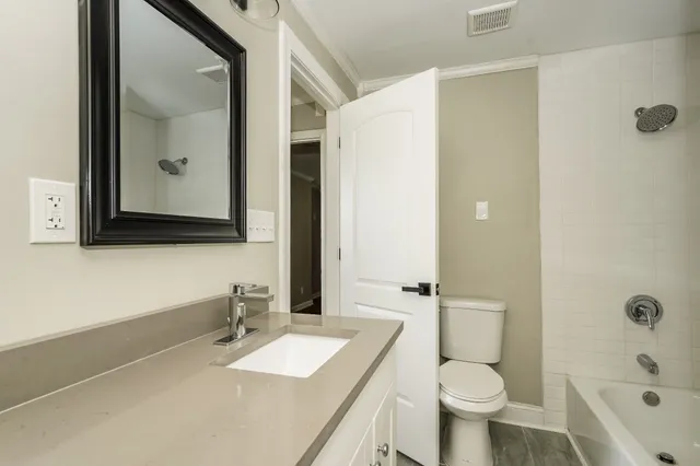 a bathroom with a granite countertop sink toilet and shower
