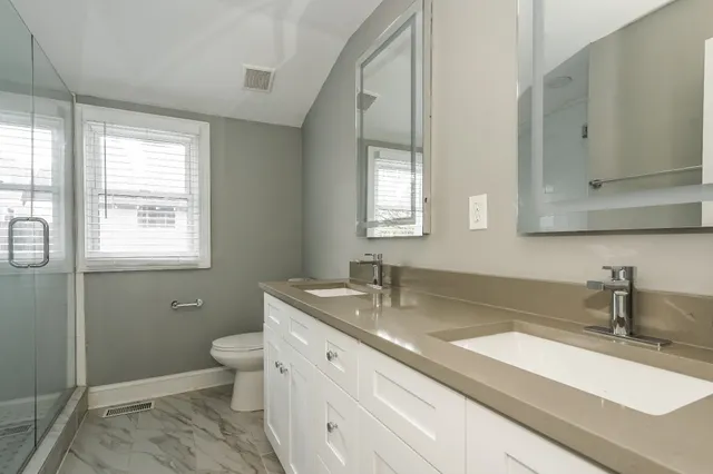 a bathroom with double sink and a toilet