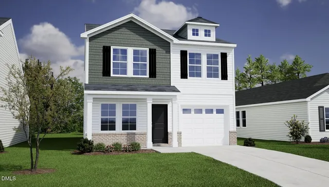 a front view of a house with a yard and trees