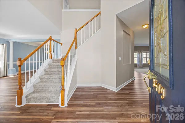 a view of a hallway with wooden floor and staircase